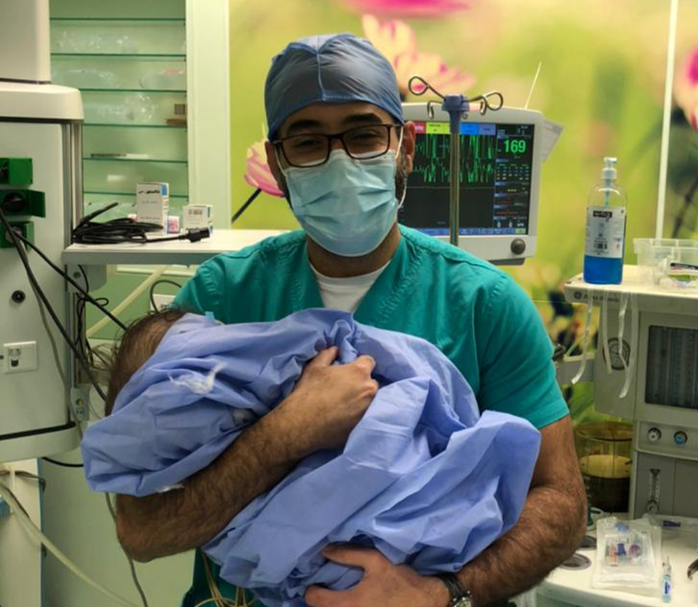 An Egyptian doctor holds a baby after a successful hydrocephalus surgery