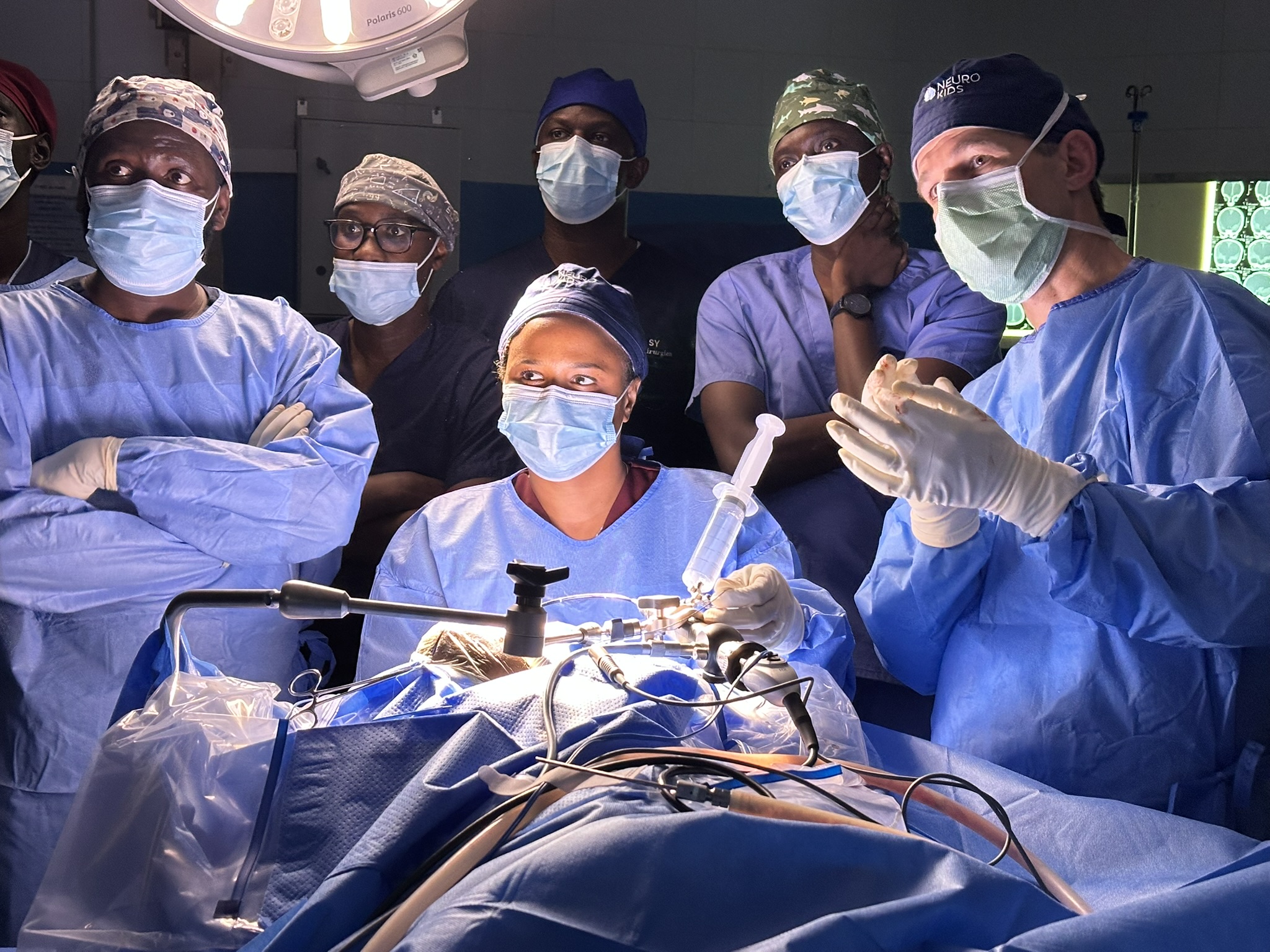 Prof Mbaye and a crowd learning an aspect of surgery.