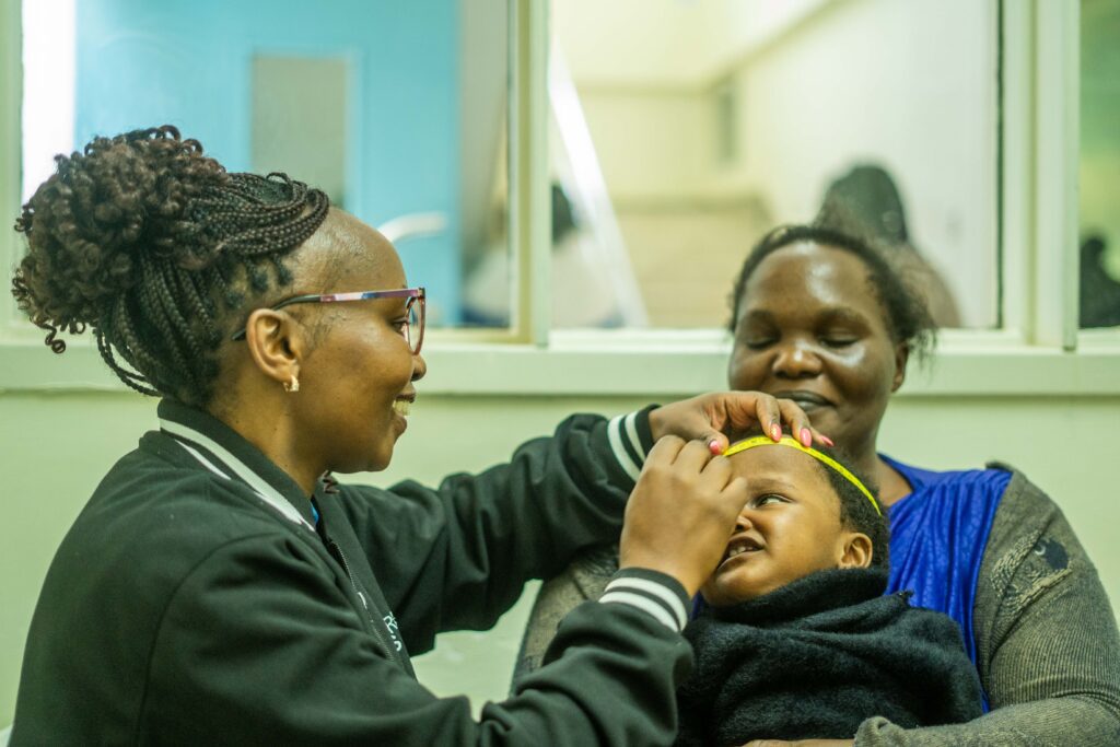 Anne measuring baby Hope’s head circumference during her follow-up appointment.